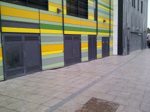 A row of retail units was originally promised to go along here: instead there are bin stores and substations. A lively street frontage it is not.